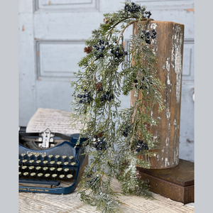 Stems of hanging greenery with blueberries