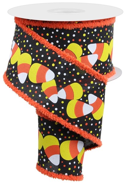 Roll of ribbon with candy corn on a black background
