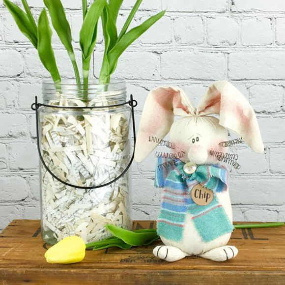 Cream colored bunny with blue plaid scarf and potted plant