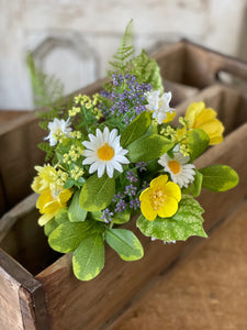 Bundle of flowers in a wooden box consisting of white daisies and yellow and purple flowers