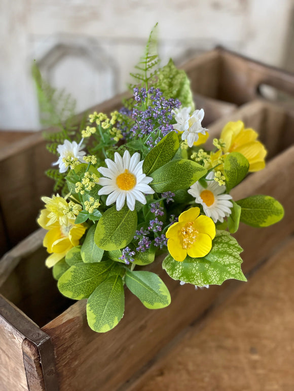 Bundle of flowers in a wooden box consisting of white daisies and yellow and purple flowers