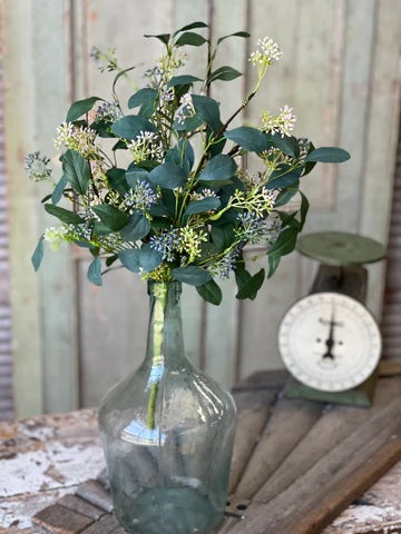Single spray of greenery in a glass vase